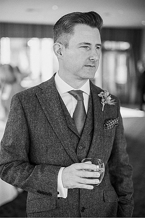groom with a drink just before the wedding