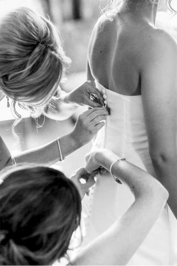wedding at stonefiled castle bride having her dress buttoned 