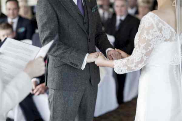 bride and groom holding hands during ceremony