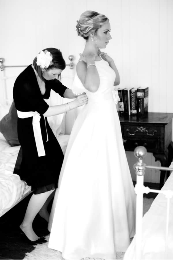 bride putting on wedding dress