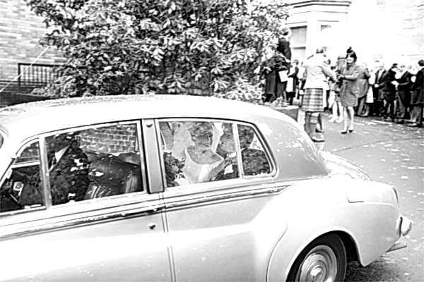 newlyweds leaving teh church in a wedding car
