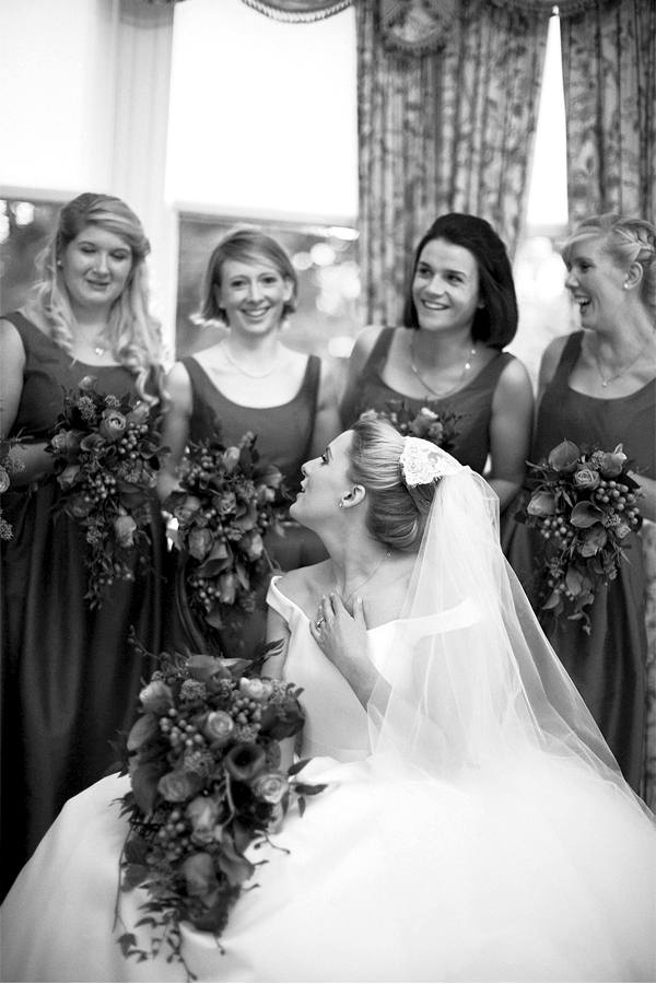bride and bridesmates laughing during wedding photo session