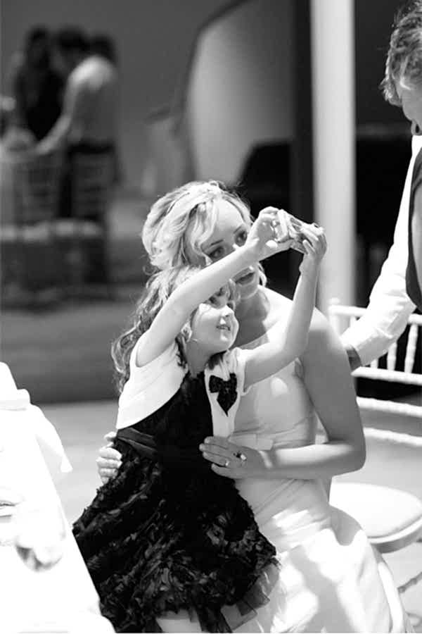 little girl take photo with bride