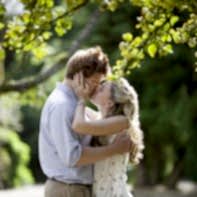 engaged couple kissing under an apple tree garden glasgow