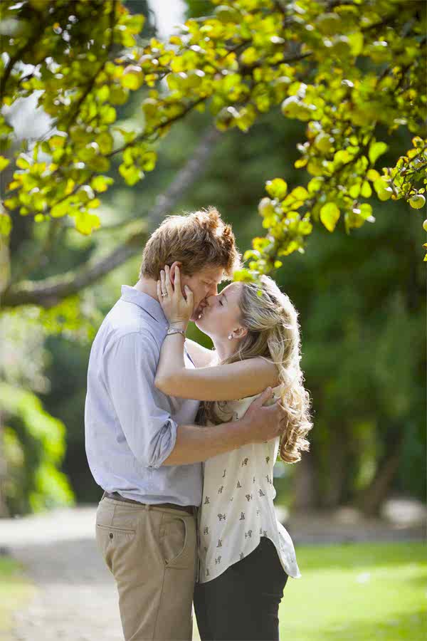 engaged couple kissing under an apple tree garden glasgow