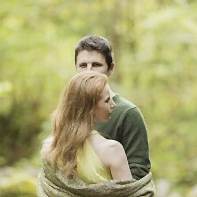 engaged couple in a forest in scotland holding each other with shawl