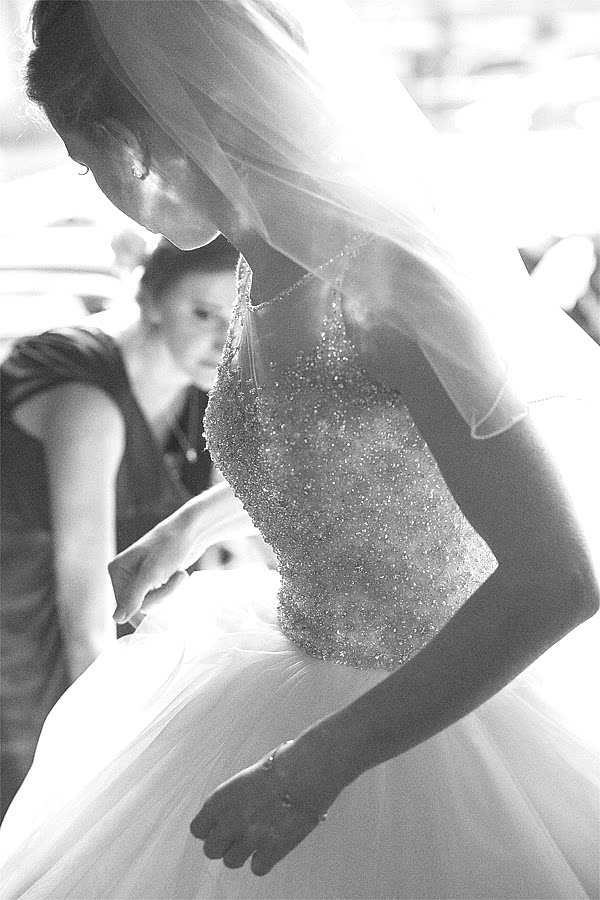 bride having her dress fixed 