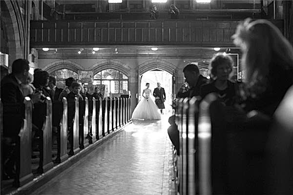 bride walking down the aisle with father in church wedding