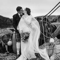 married couple kissing in an old harbour scotland isle of harris