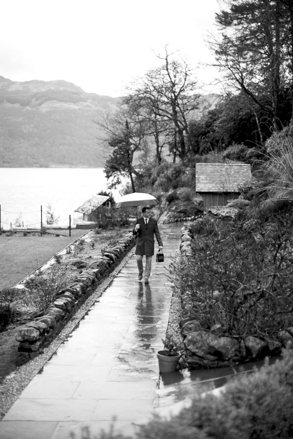groom walking in the rain for ceremony at the lodge on loch goil scotland