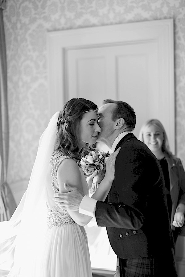 father kissing the bride after seeing her in the wedding dress