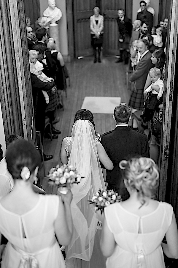 bride walking down with father and bridesmates for ceremony