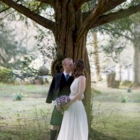 couple kissing during wedding under tree at blairquhan castle wedding photographer ayrshire