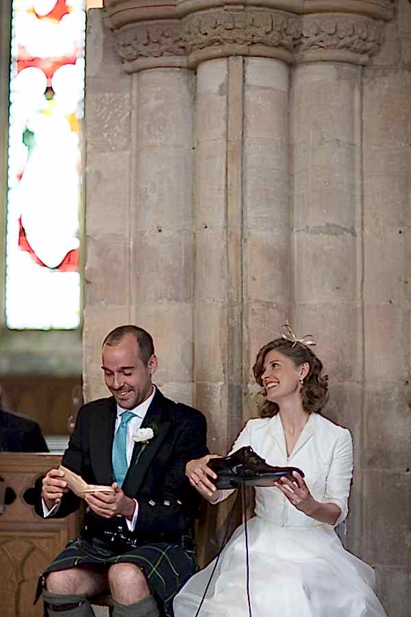 funny image of bride and groom holding their shoes