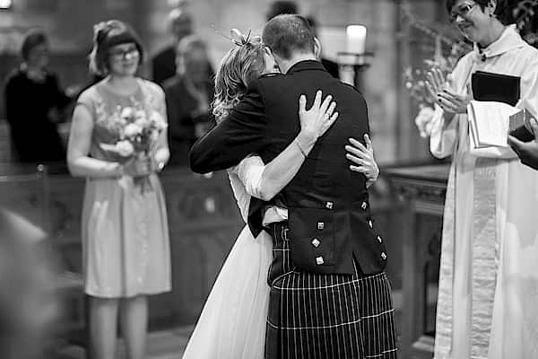 bride and groom embraced during church wedding ceremony
