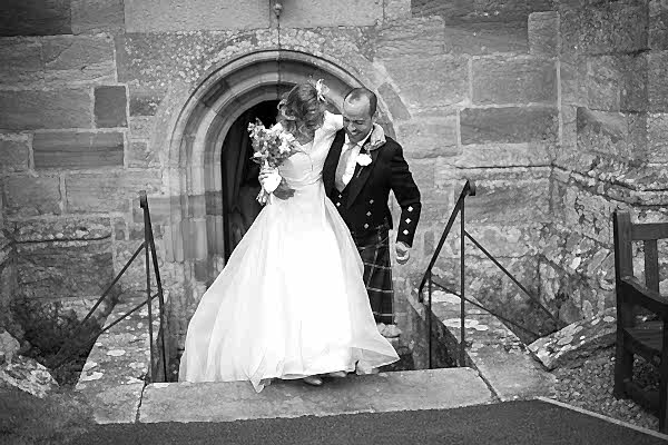 groom lifts the bride on the steps from the church fotogenic of scotland