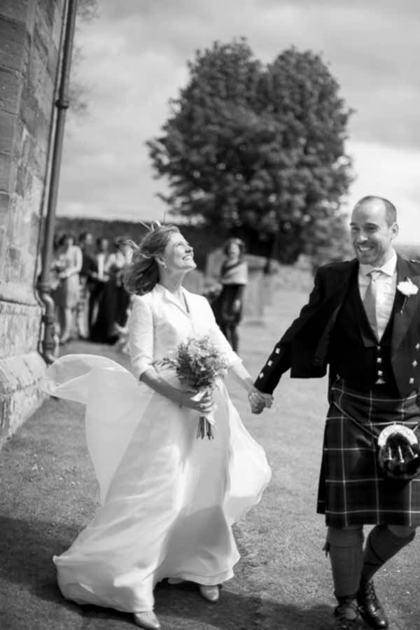 bride and groom very excited just married outside the church in scotland