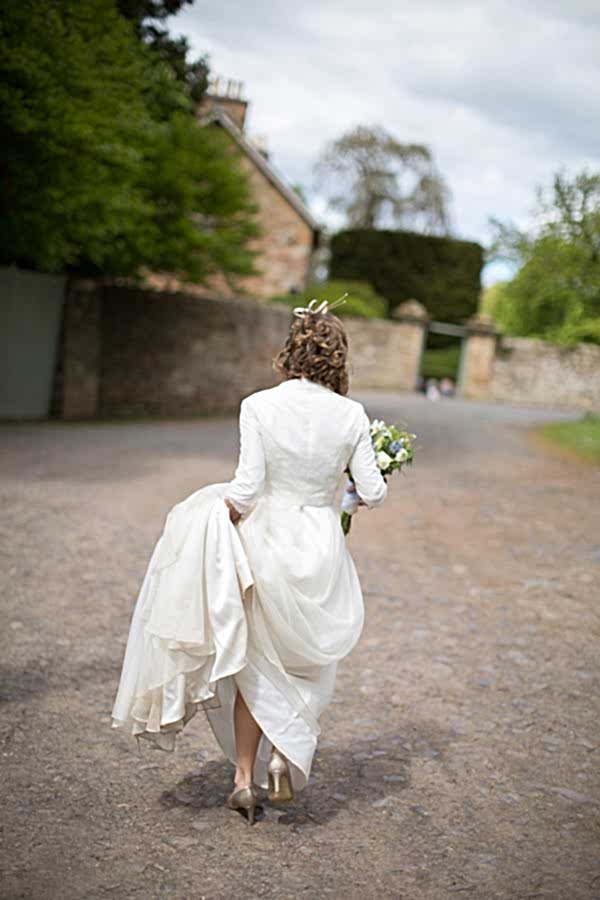 bride walking alone holding her dress