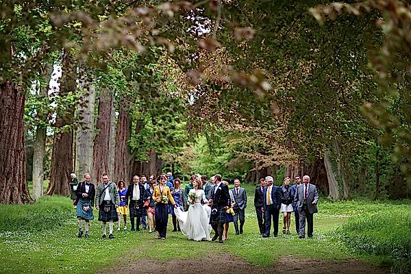 bride and groom leading the procession of guests to wedding venue near edinburgh