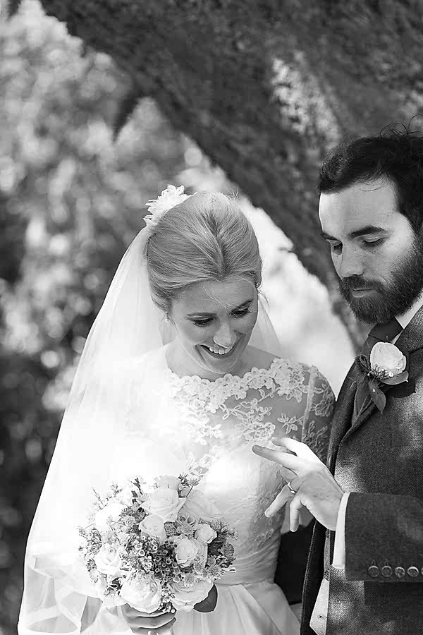 groom nad bride looking at wedding ring