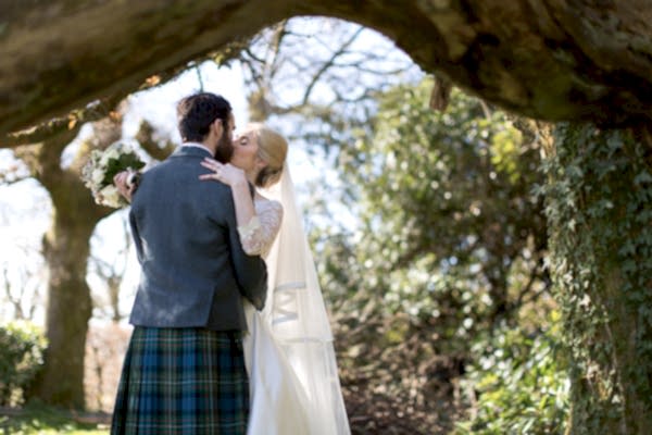 just married kissing under a large tree loch lomond wedding photographer