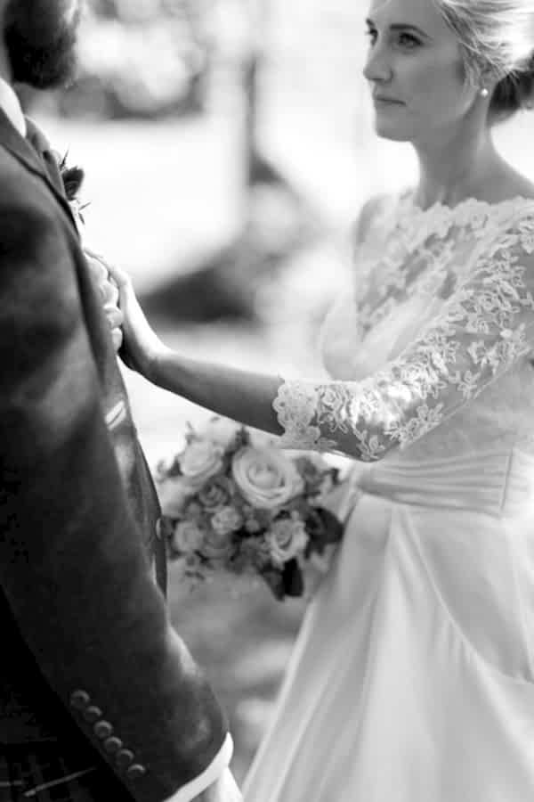 bride puttinh her hand on grooms chest looking at each other
