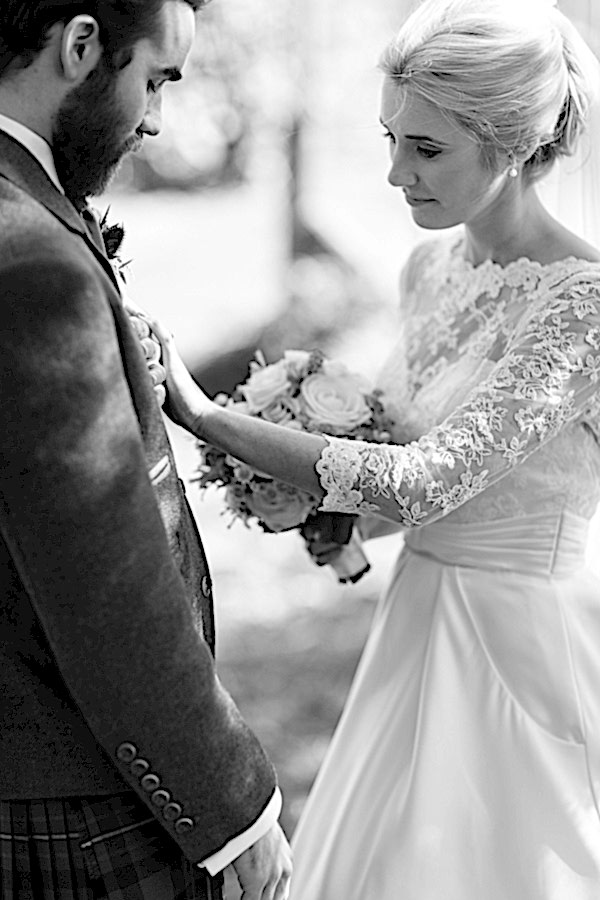 newlyweds looking down on their wedding rings at boturich castle