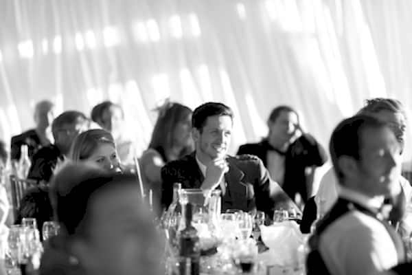 guests loooking at the groom during speech