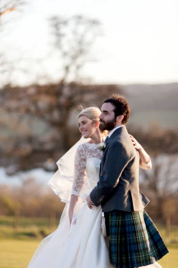 newlyweds looking away with loch lomond in background