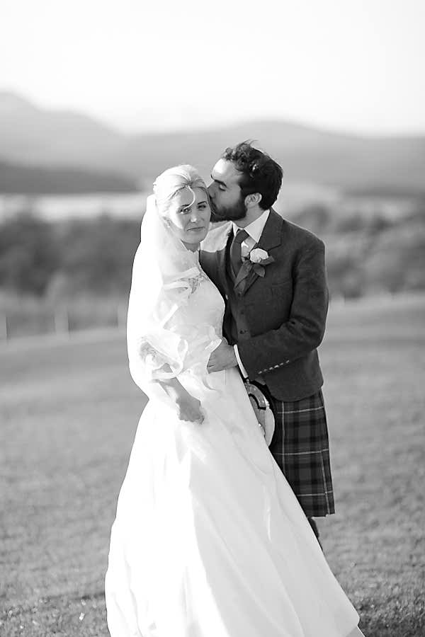 groom kissing bride in a cheek at boturich castle
