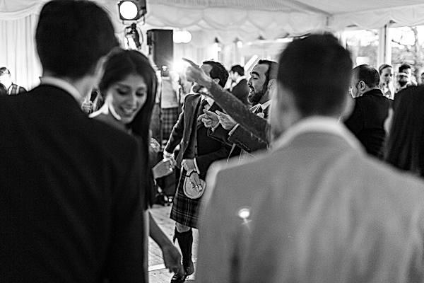 wedding guests dancing with groom and best man