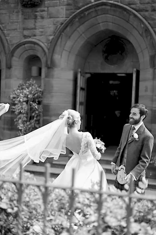 newlyweds outside veil beeing lifted by the wind