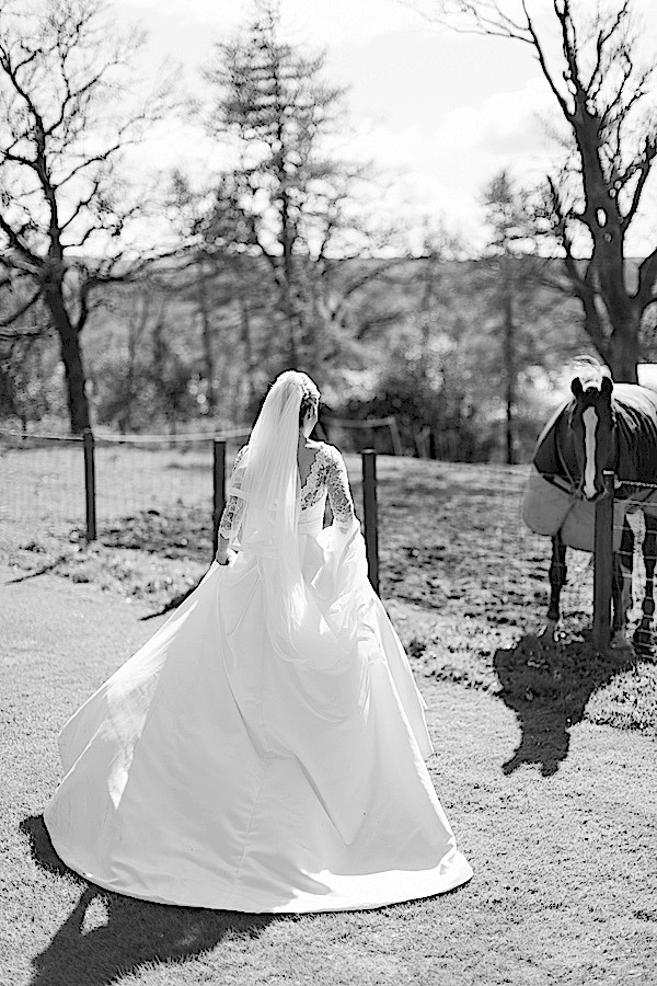 bride walking closer to a horse at boturich castle on loch lomond wedding