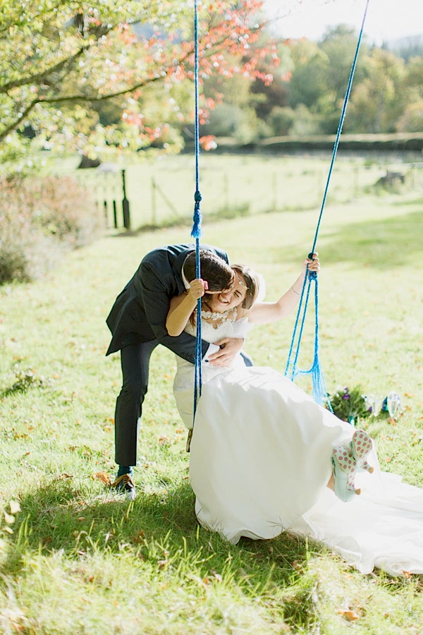 bride and groom embraced kissing on swing near glasgow
