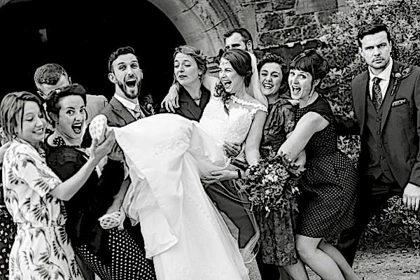bride beeing lifted by groom and friends