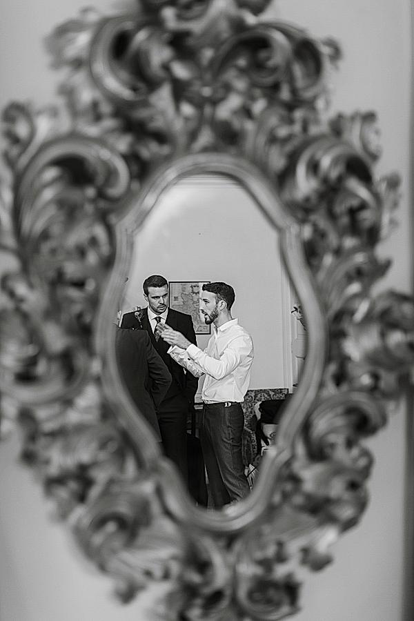 mirro relfection of groom talking to groomsmen scotland