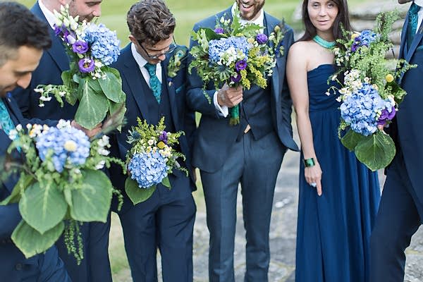 groom and grooms party holding flowers