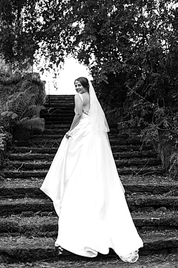 bride standing on stairs with long wedding dress