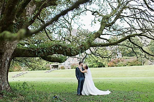 bride and groom under large tree in ardkinglas garden photo by fotogenic of scotland