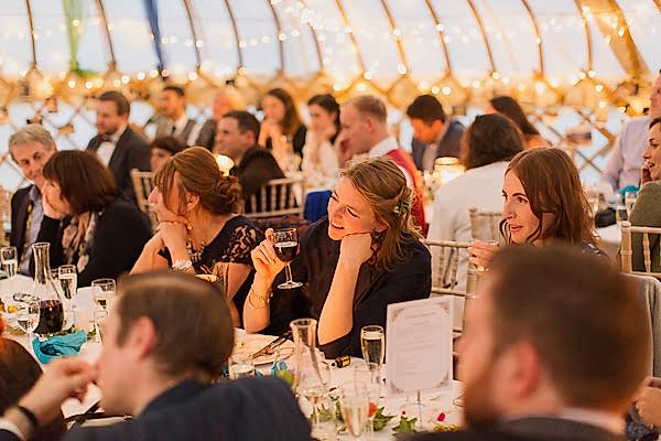 wedding guests during speeches in tipi tent