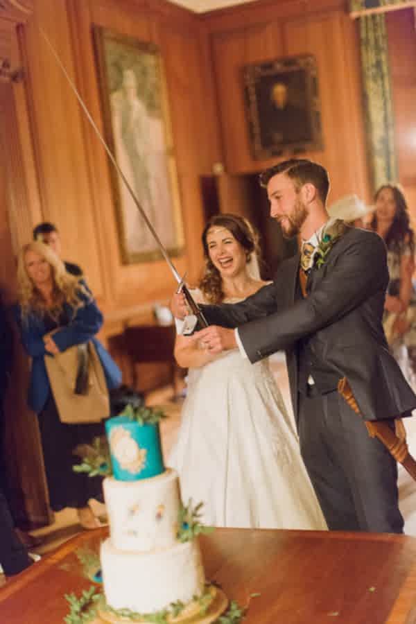 bride and groom preparing for cutting of the cake with sword in scotland