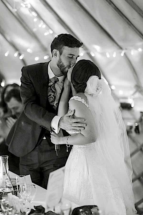 bride and groom kissing during speeches