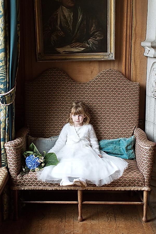 flower girl sitting looking through the window