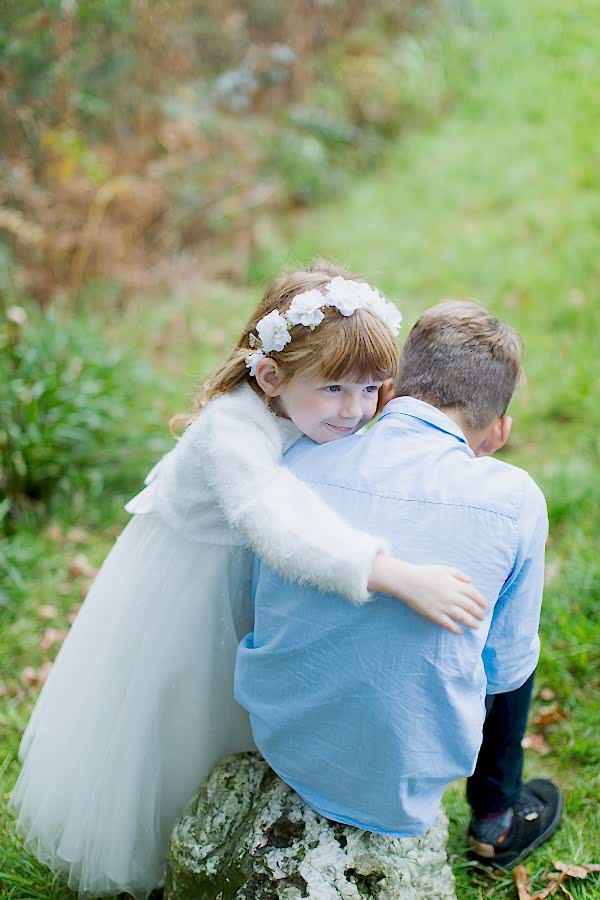 flower girl huging his brother before ceremony