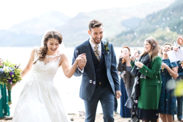 wedding photographer glasgow, bride and groom walk out from ceremony with bubbles outdoors ceremony near glasgow