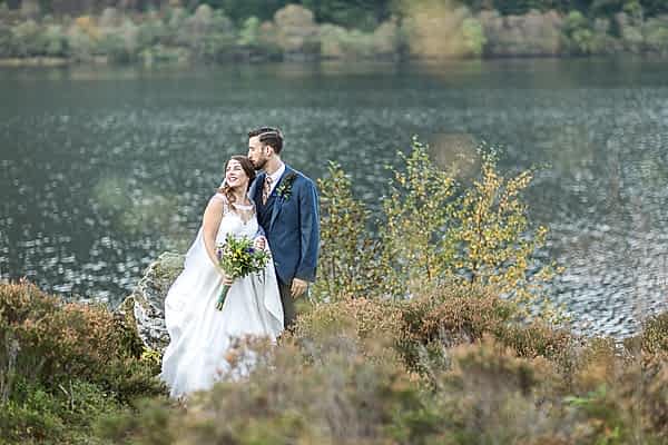 wedding photography groom is kissing bride at loch eck scotland 