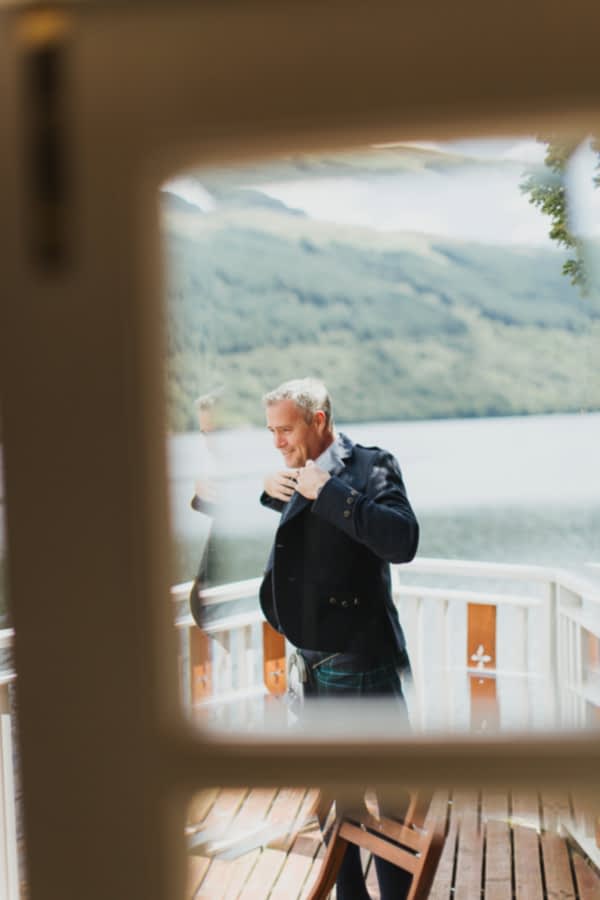 groom putting his jacket on during preparations