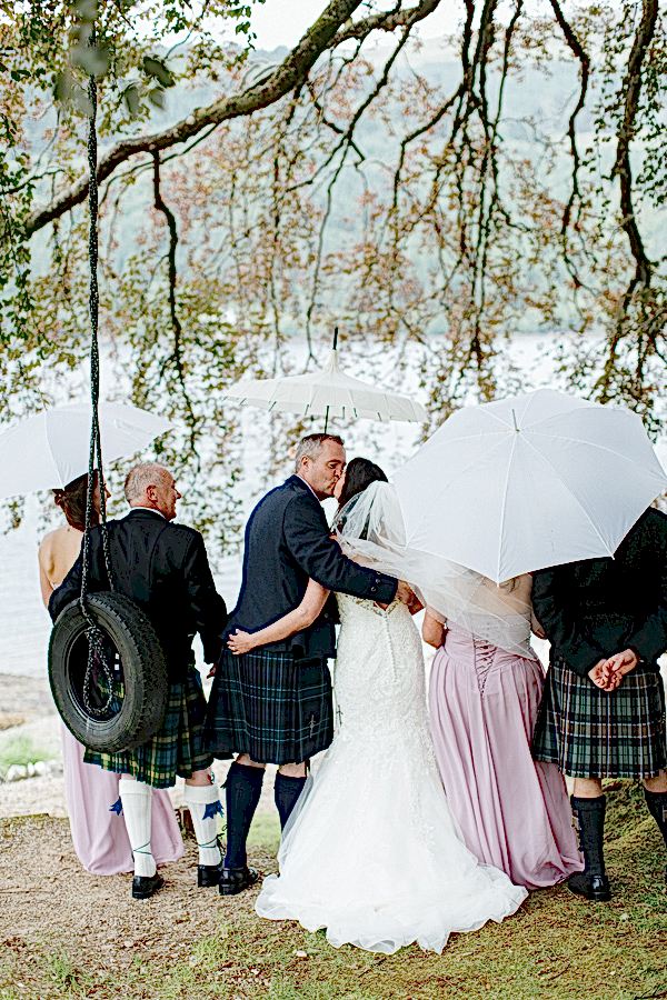 bridal party under big tree with umbrellas