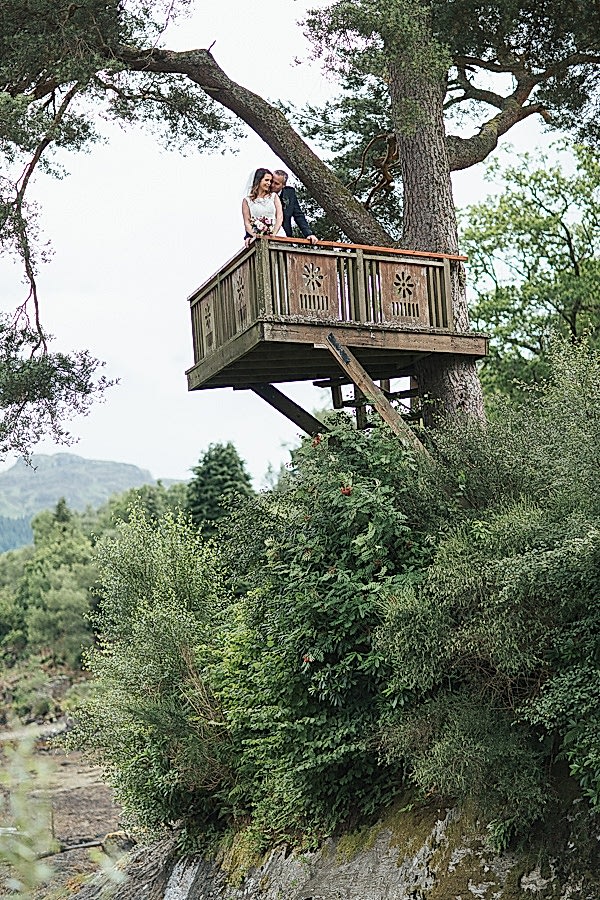 bride and groom embraced on a tree podium