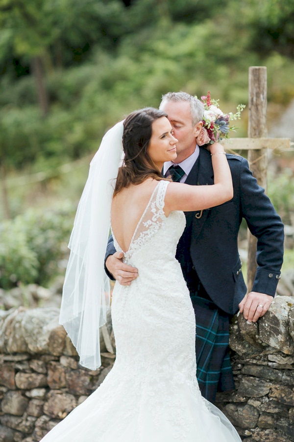groom kissing bride on a cheek 